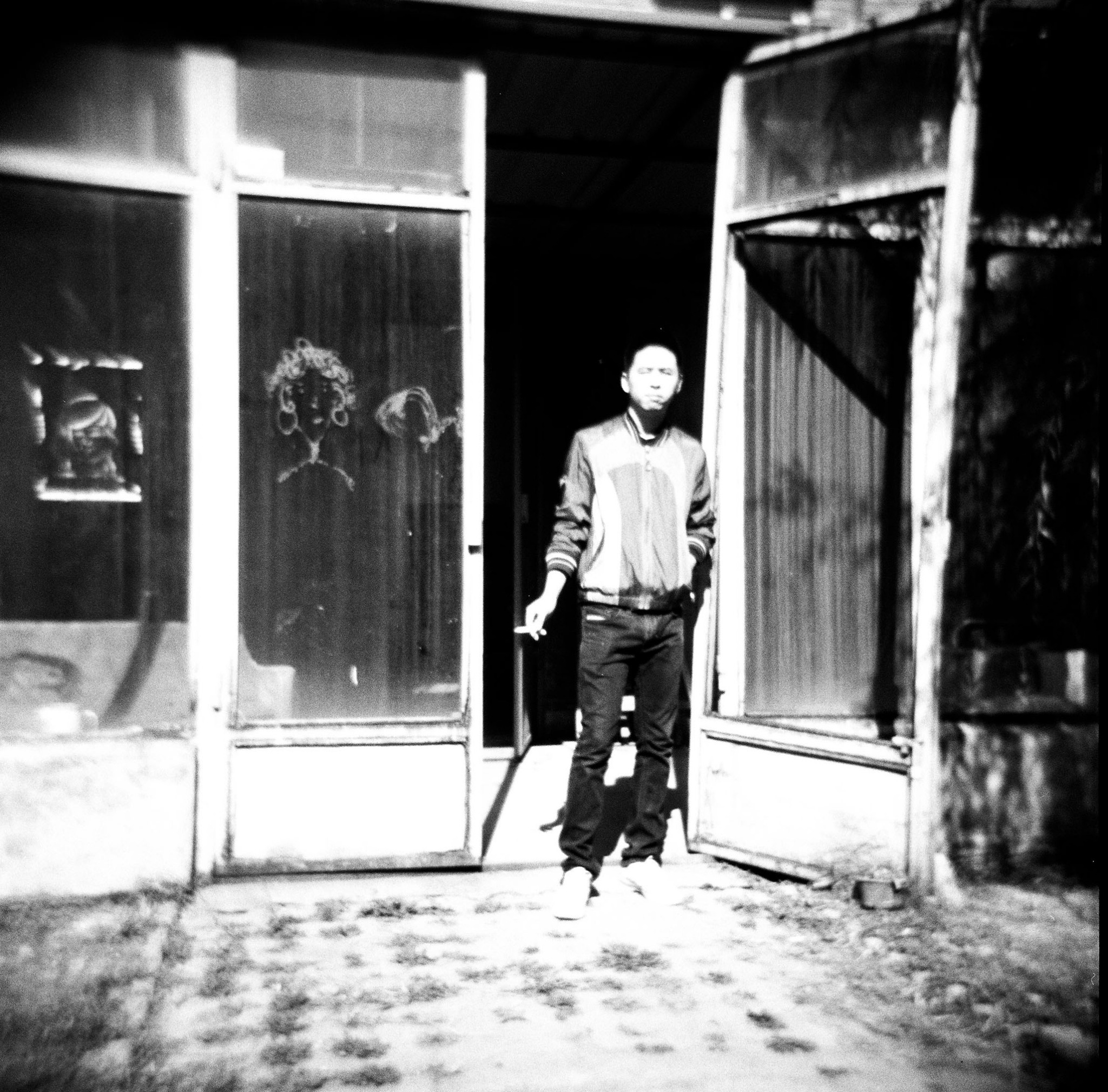 Black-and-white photograph of a figure in a doorway